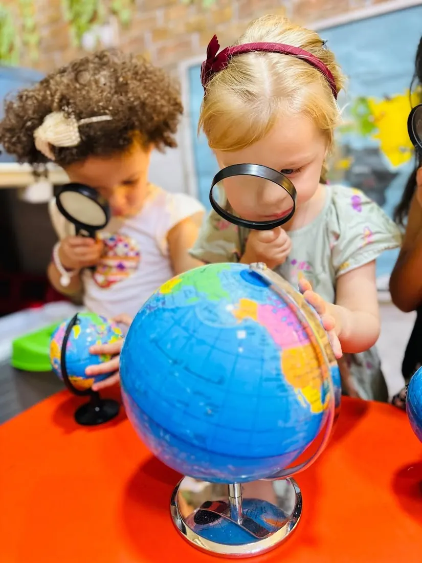 Looking closely at the globes with magnifying glasses